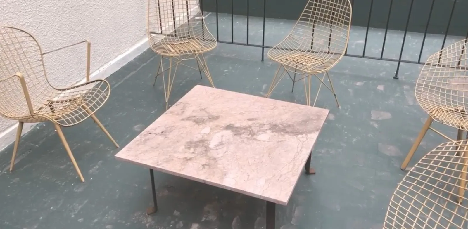 antique coffee table in a modern setting with gold chairs