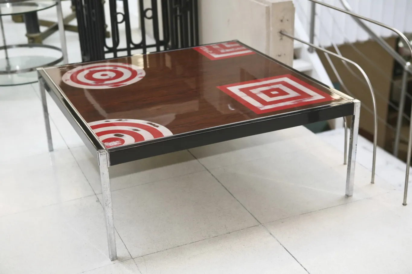 Antique coffee table with geometric design on top, surrounded by an elegant environment