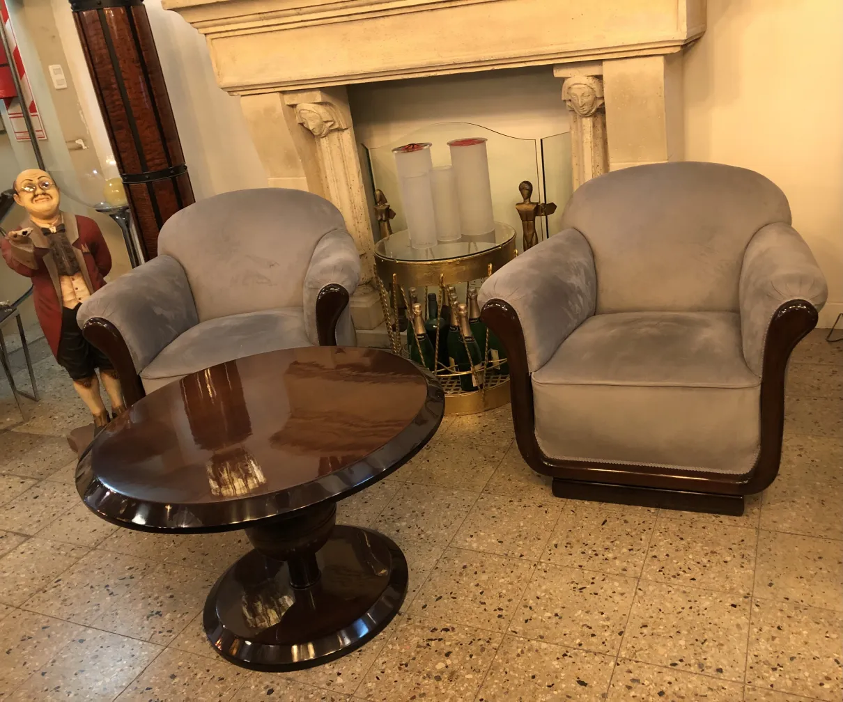 Mesa ratona antigua de forma ovalada en salón acogedor con sillones.