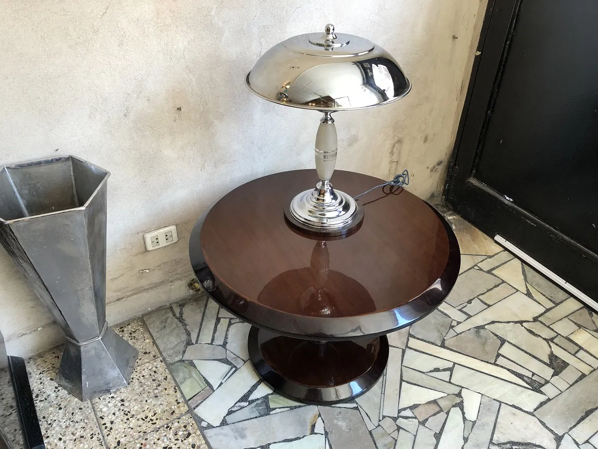 Mesa de centro antiga com lâmpada em um ambiente de piso de mosaico.