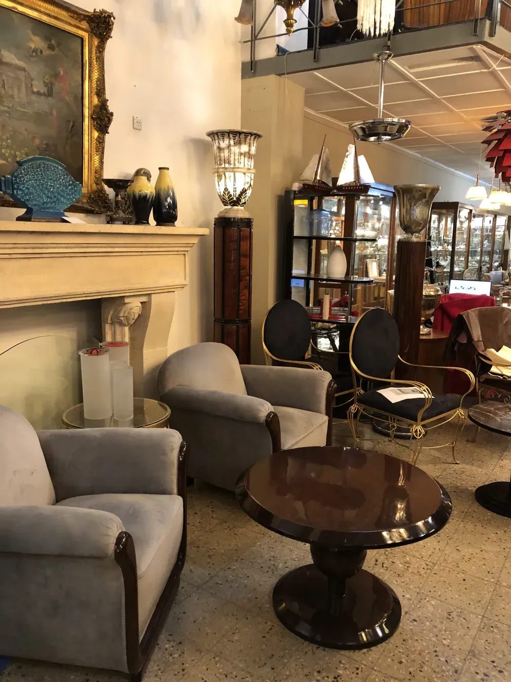 Mesa ratona antigua en un ambiente con sillones suaves y decoración clásica.