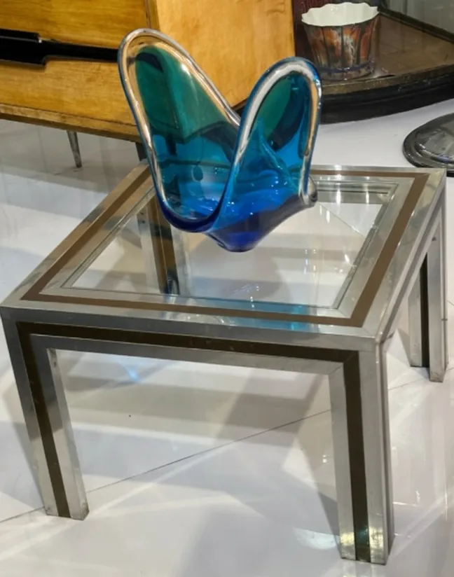 mesa de centro antiga com um vaso azul em cima