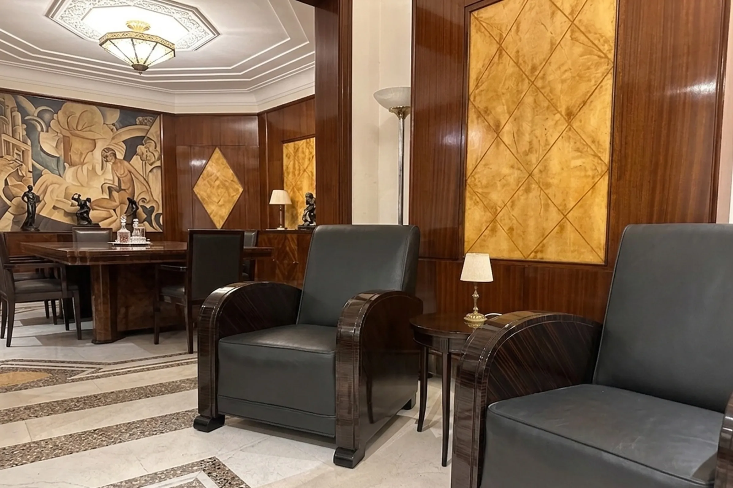 2 fauteuils anciens dans un salon élégant avec lampe.