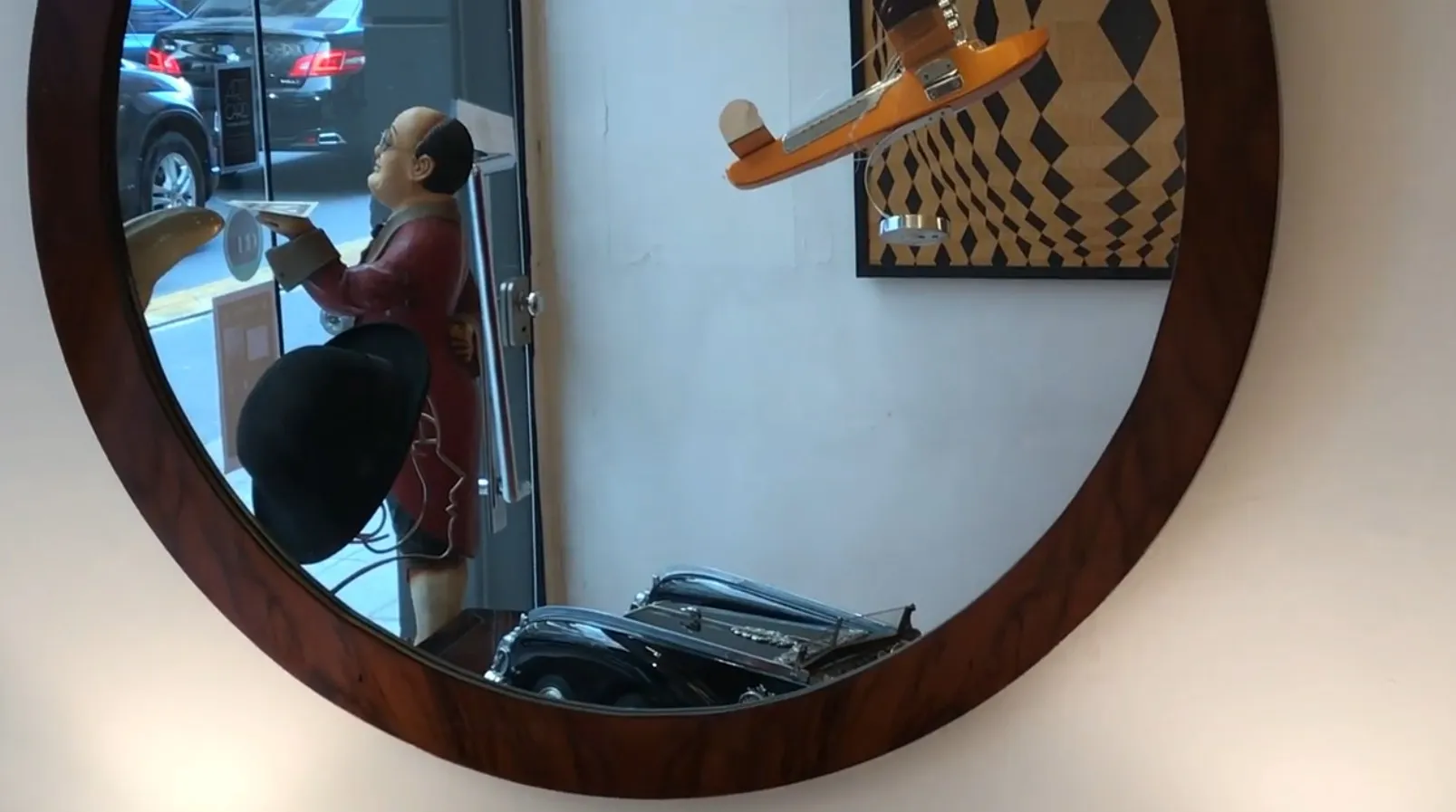 Espelho antigo circular com detalhes decorativos, refletindo um ambiente artístico.