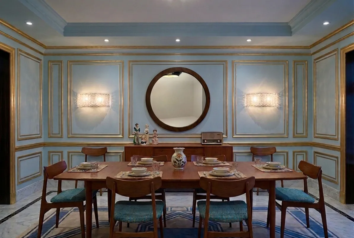 Specchio antico rotondo su sfondo blu con decorazioni dorate.