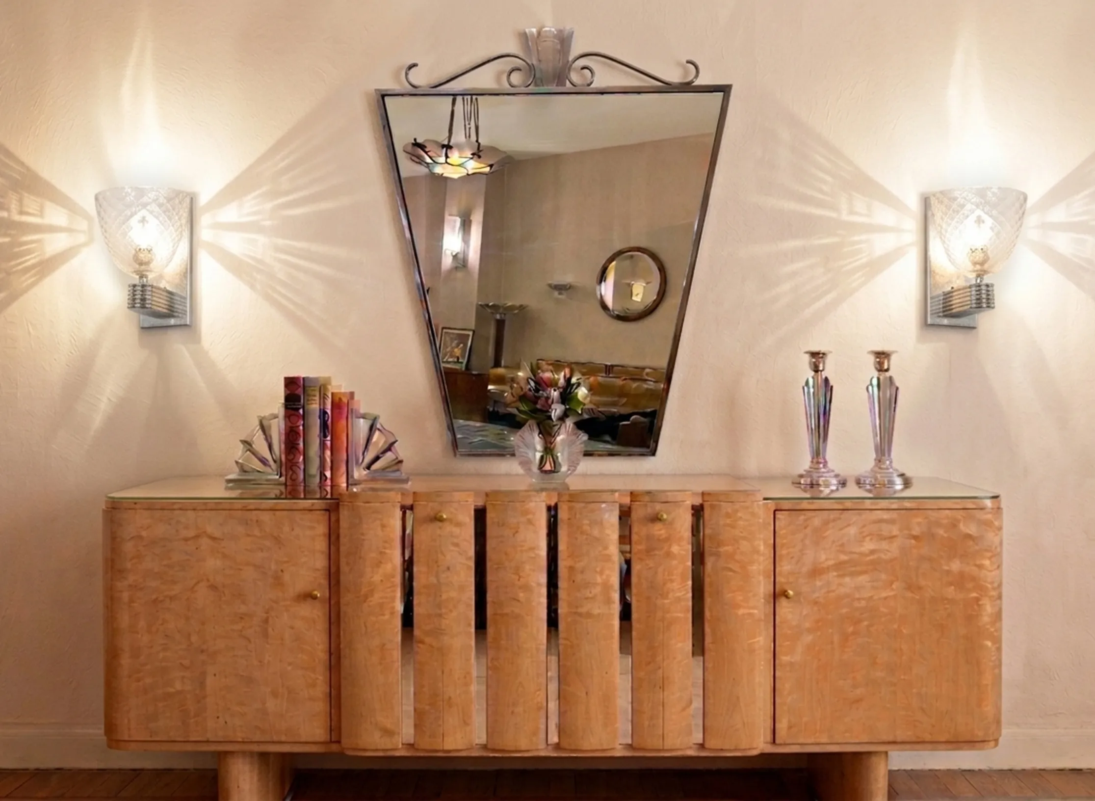 Antique pair of sconces illuminating a vintage furniture with mirror