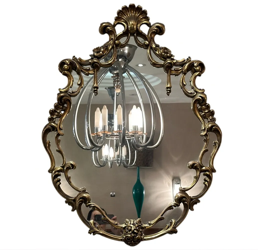 antique decorative mirror with ornate frame, light in background