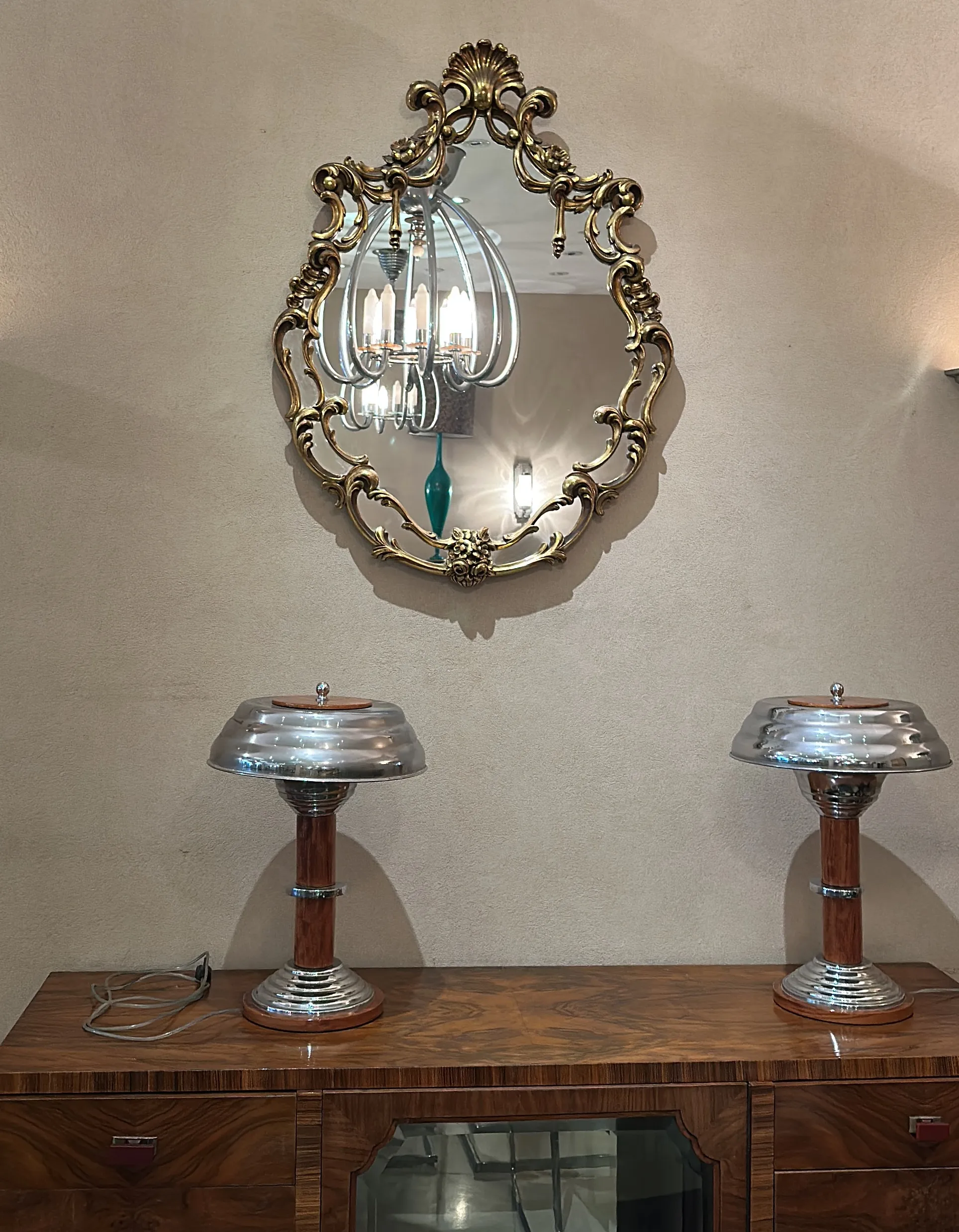 antique mirror with an intricate decorative frame and lamps on the table