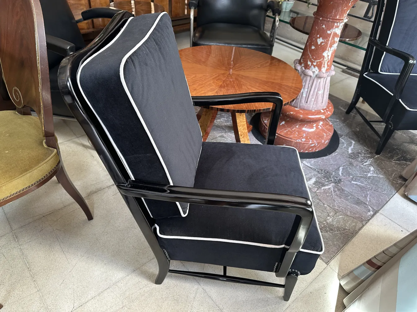 dos sillones antiguos negros con acentos en blanco en un entorno elegante