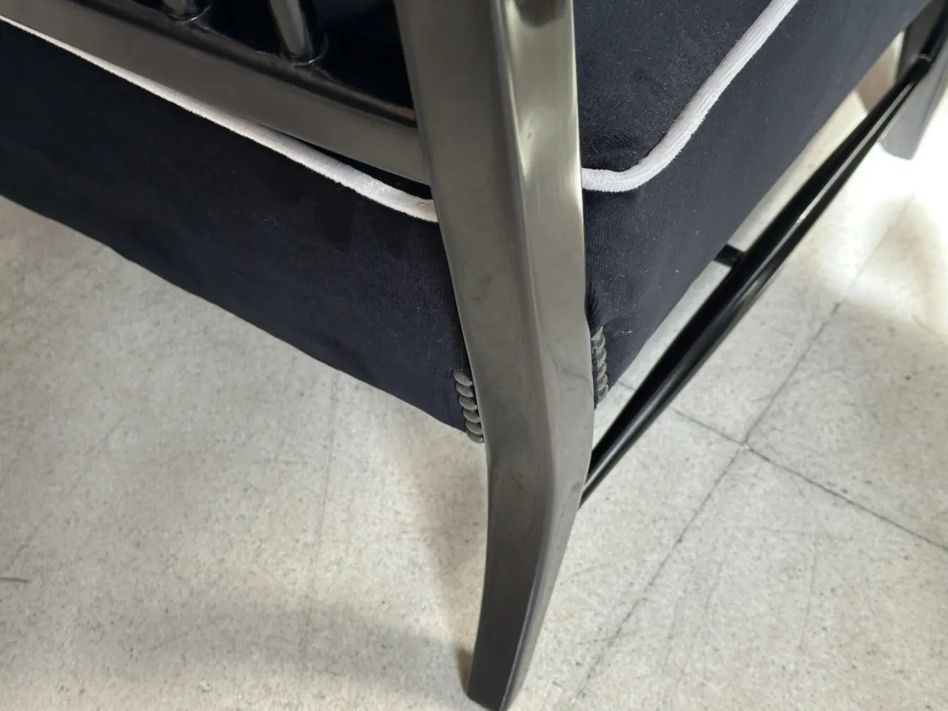 Vista lateral de 2 poltronas antigas, estofadas em azul escuro, com design elegante em um ambiente minimalista.