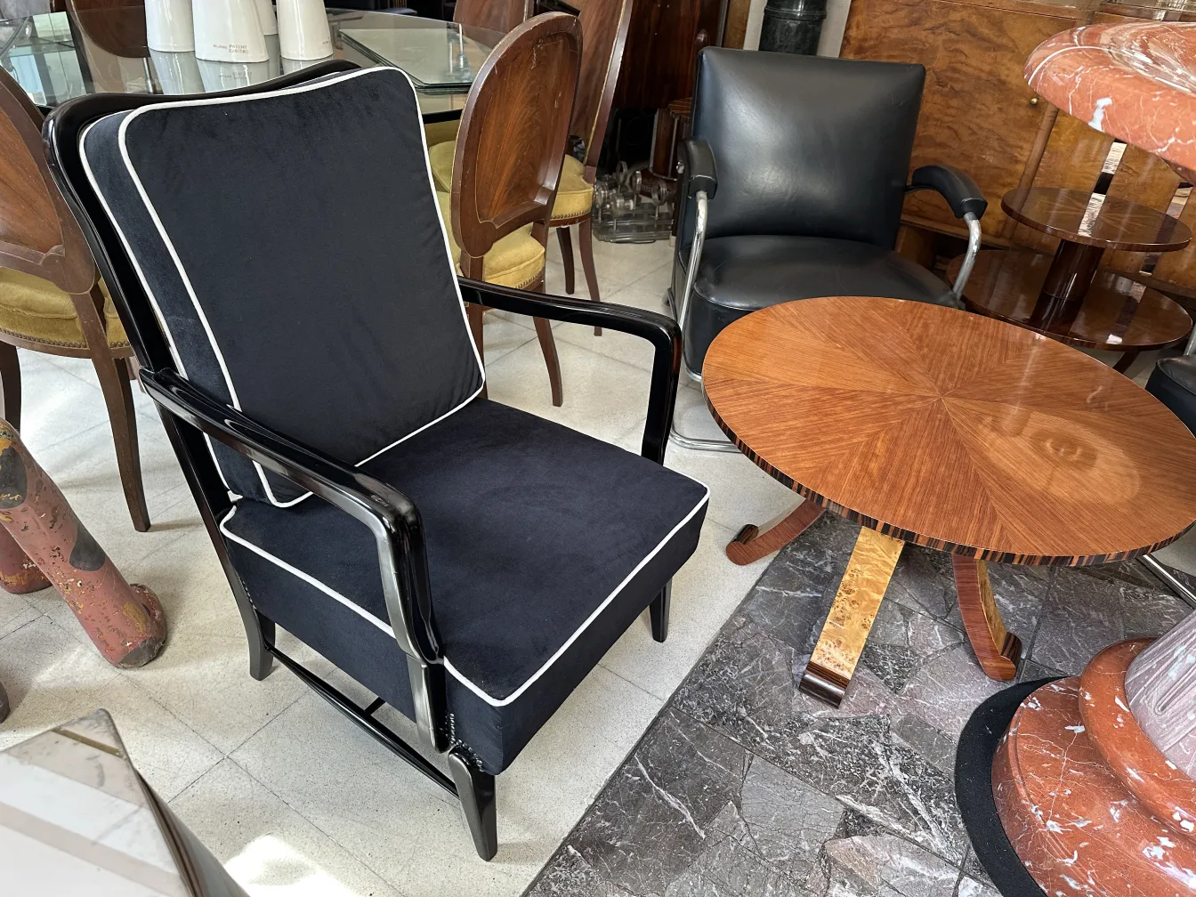 dos sillones antiguos con acolchado negro y detalles