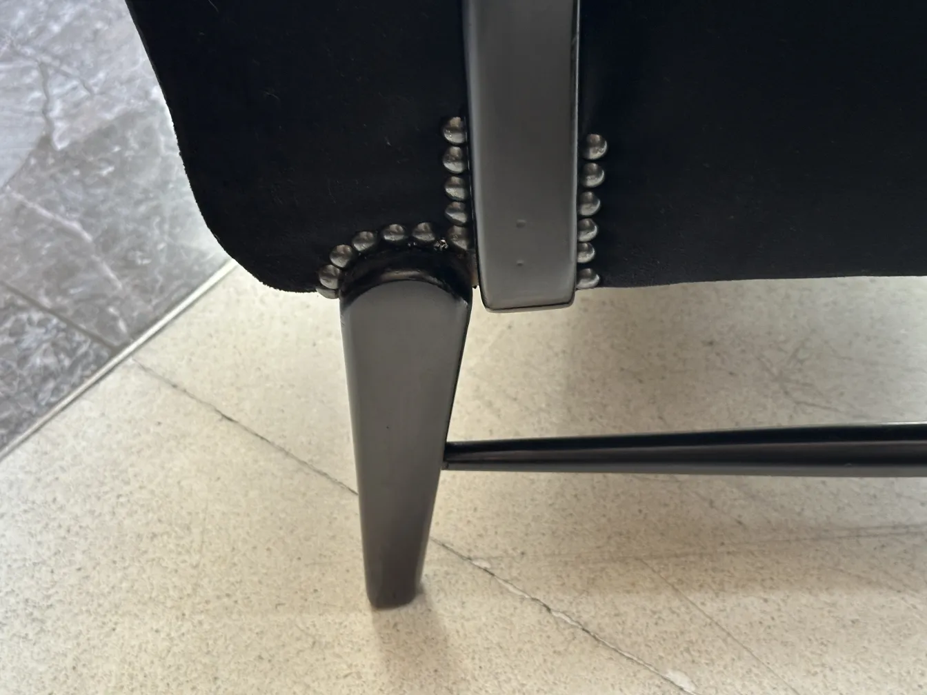 Vista cercana de 2 sillones antiguos con detalles metálicos decorativos