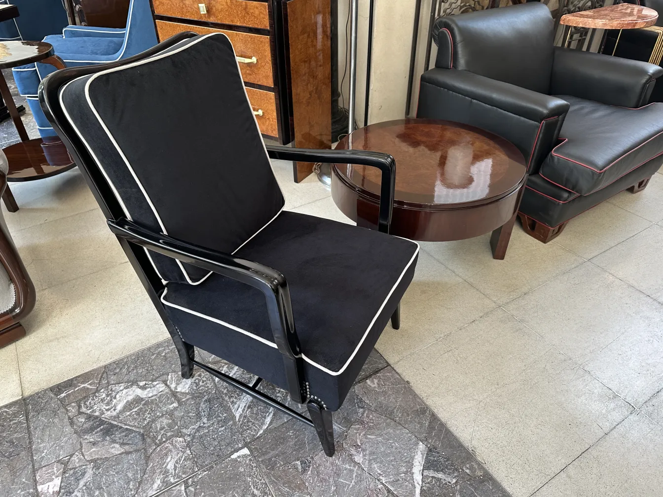 Two antique armchairs with dark cushions and light details in an elegant setting.