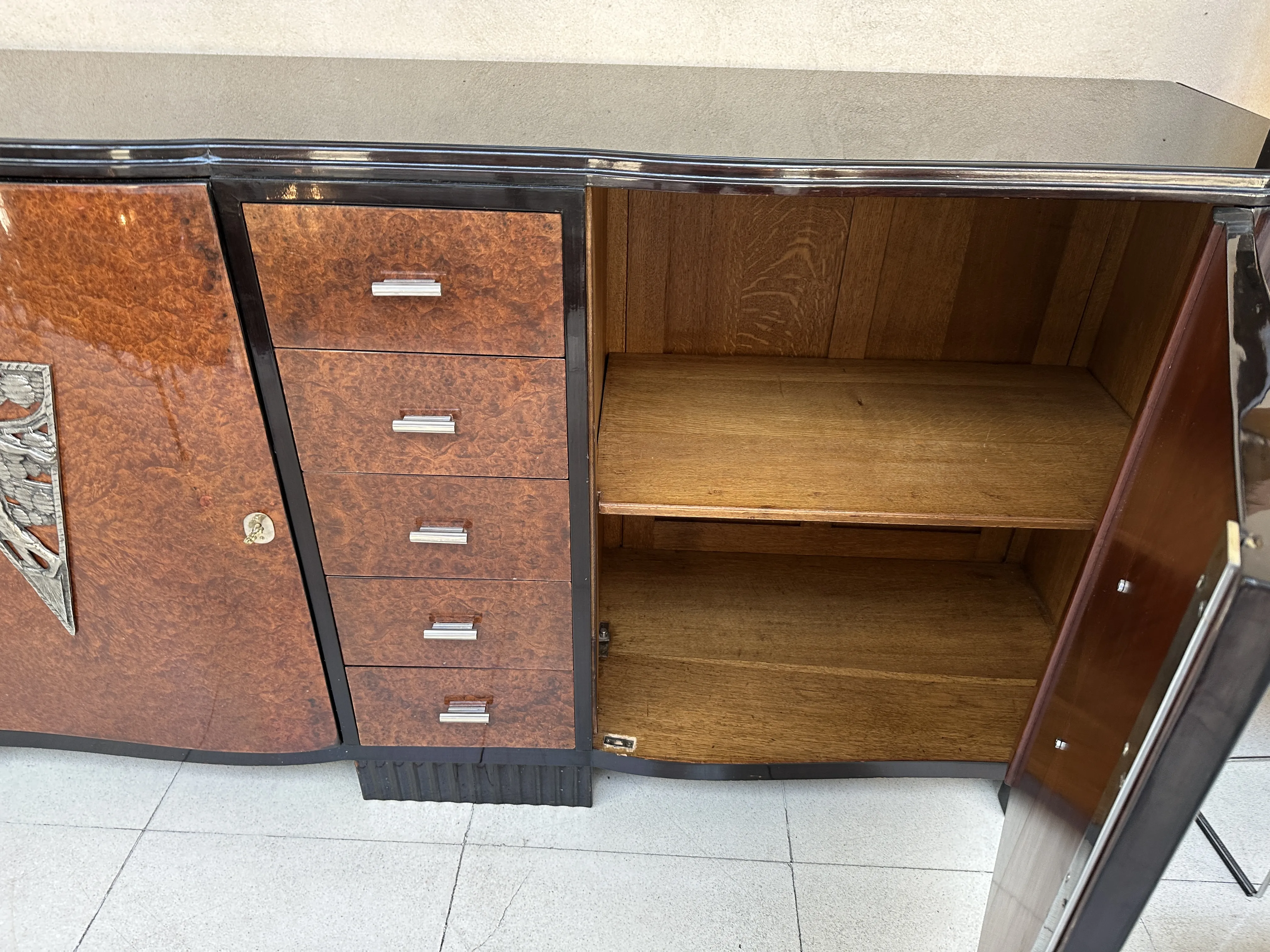 credenza antica con scaffali visibili e porte elegantemente progettate in un ambiente neutro.