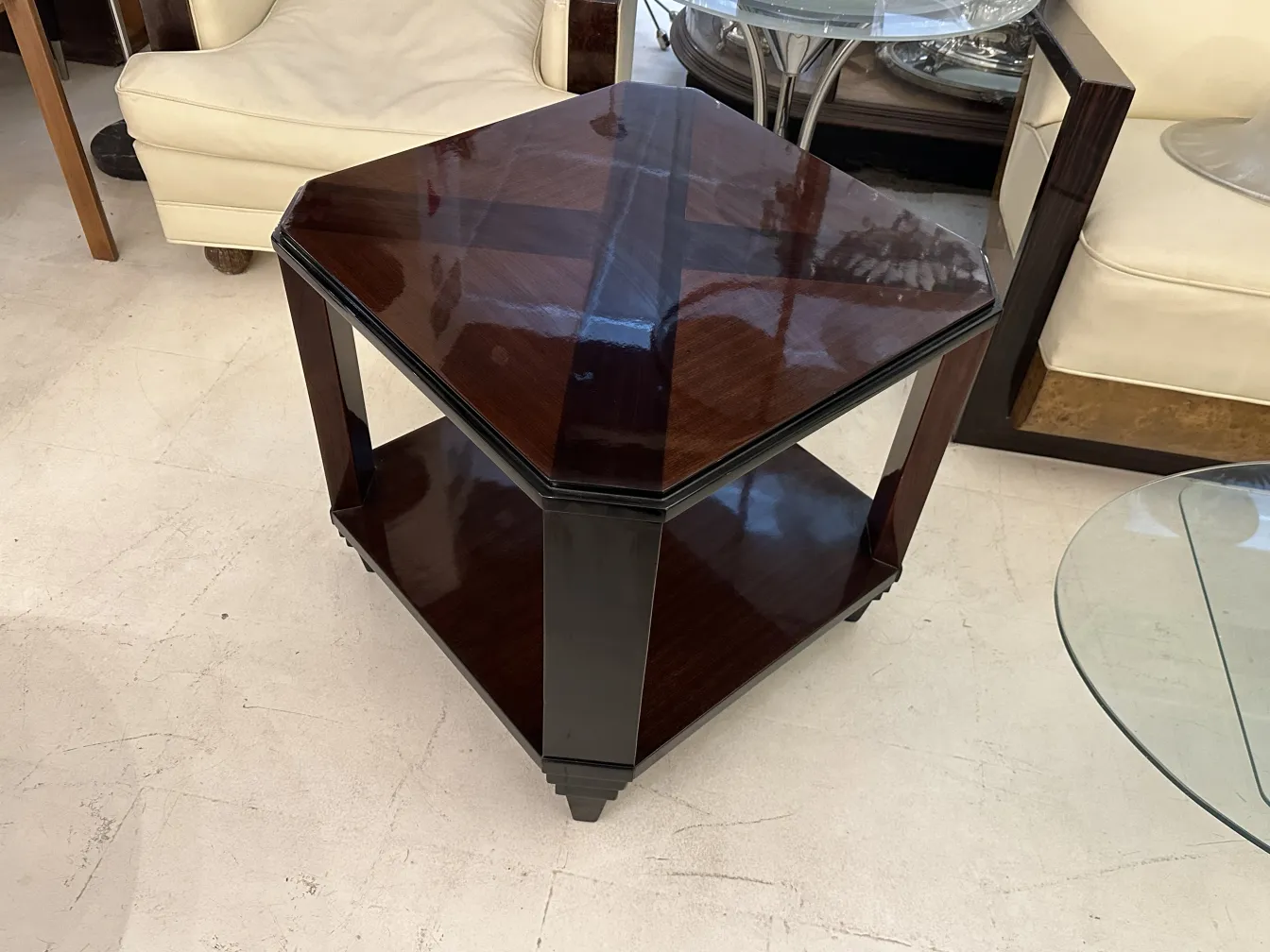 Antique coffee table in Art Deco style with hexagonal shape and two levels in an elegant setting.