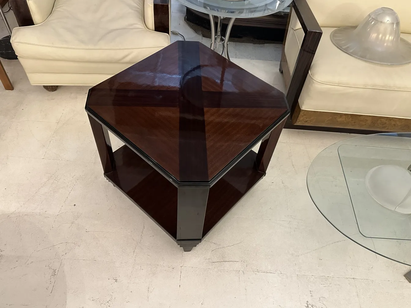 Antik-Couchtisch im Art Deco-Stil, sechseckig mit glänzender Oberfläche, in einem Raum mit modernen Möbeln ausgestellt.