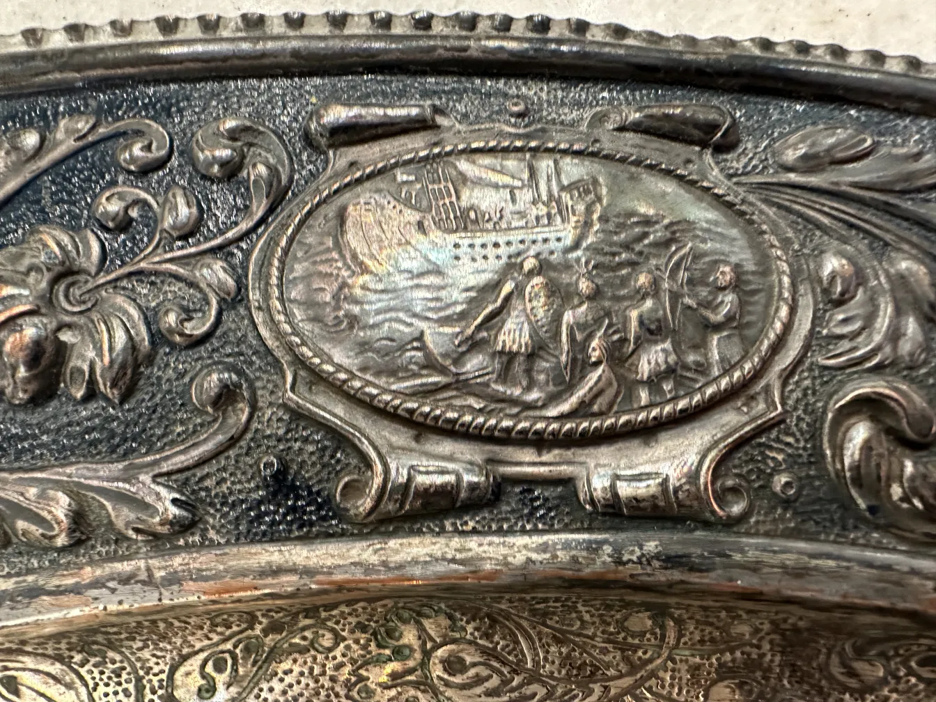 ancient wall plate depicting a sailing scene with human figures.