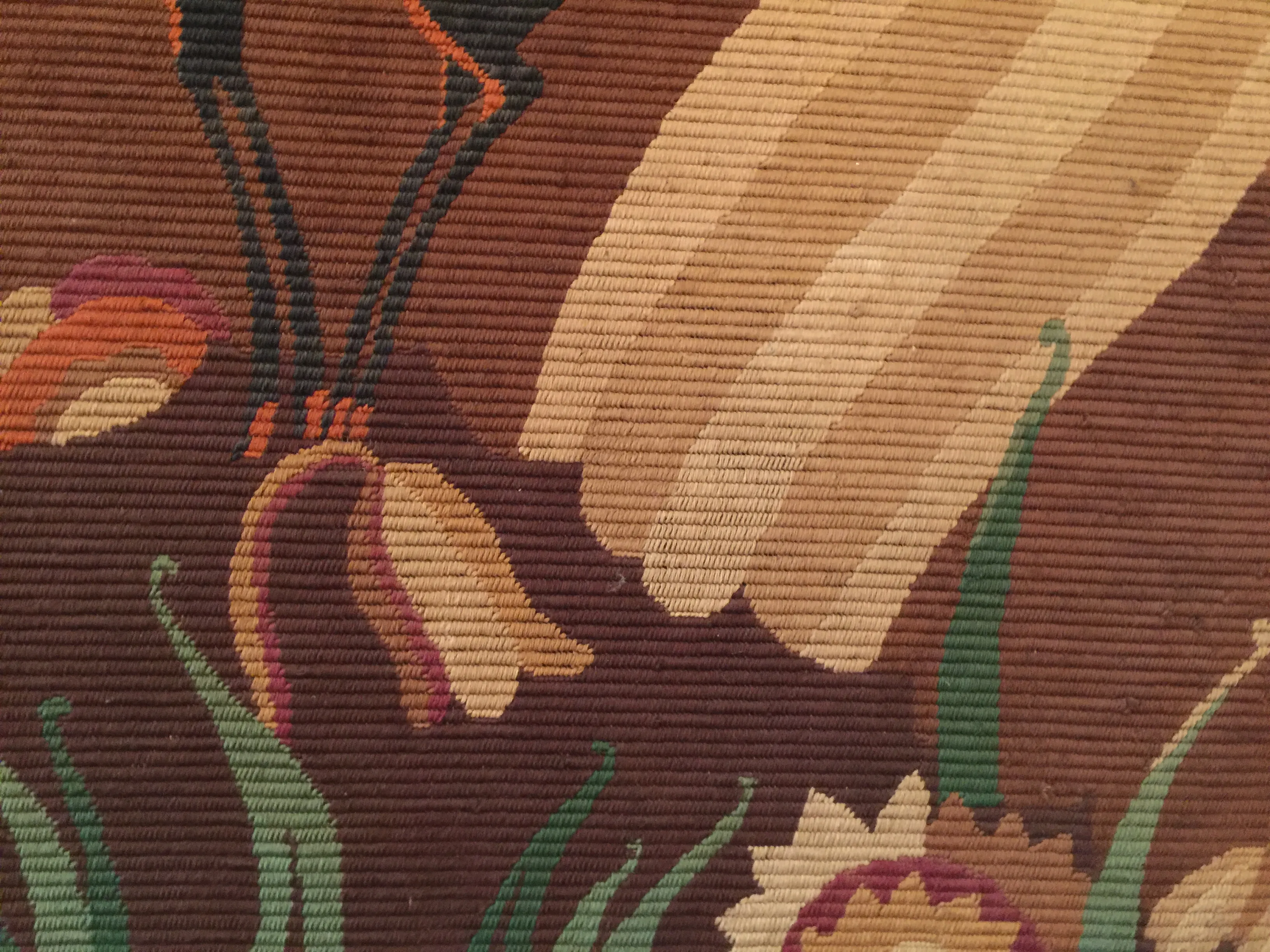 温かな色合いの花のディテールがある古いタペストリ