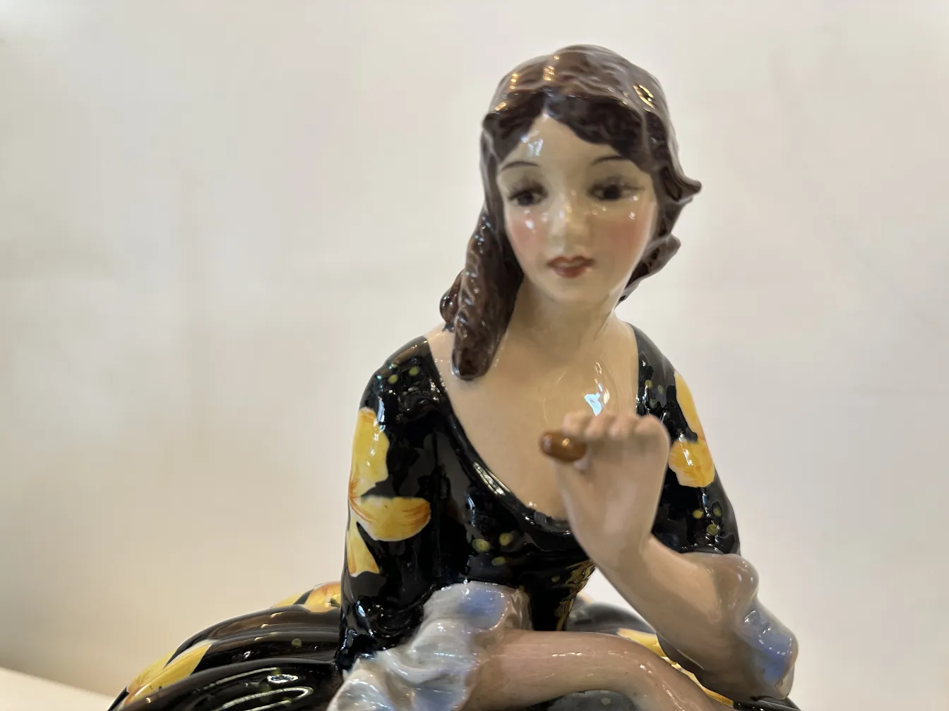 Figura decorativa de cerámica antigua de una mujer con flores
