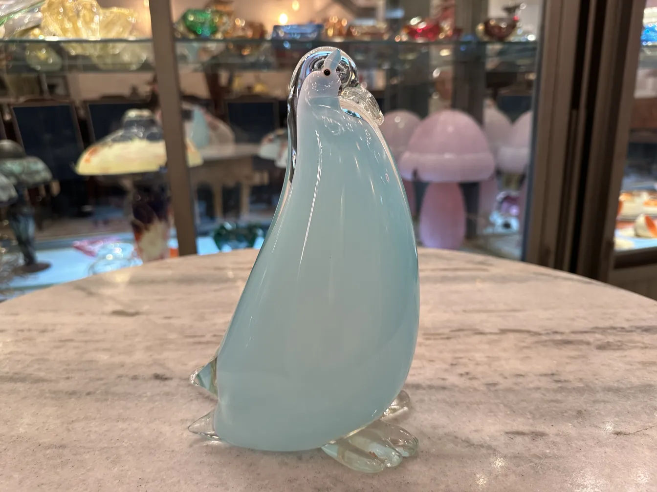 escultura antiga de murano em forma de pinguim, cores suaves