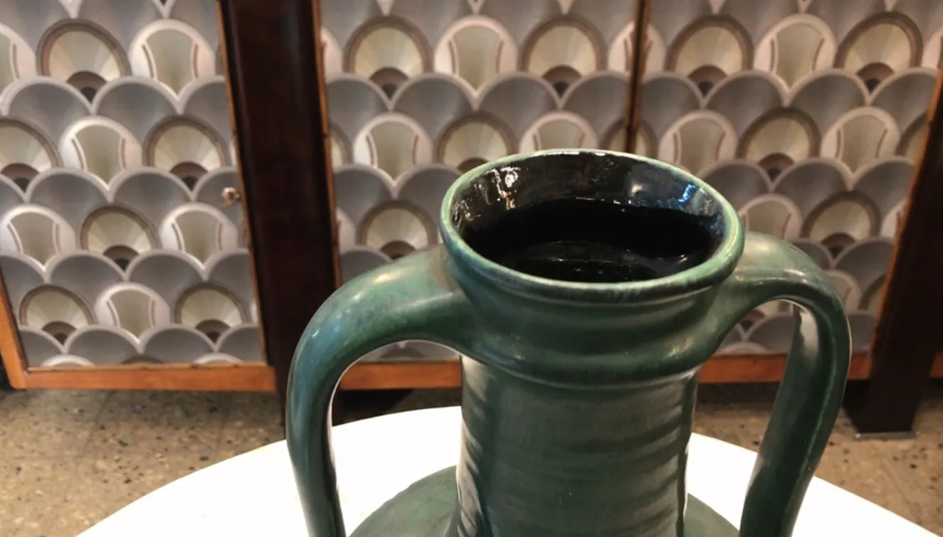 Antique green ceramic jug from Carstens Tönnieshof, white background.