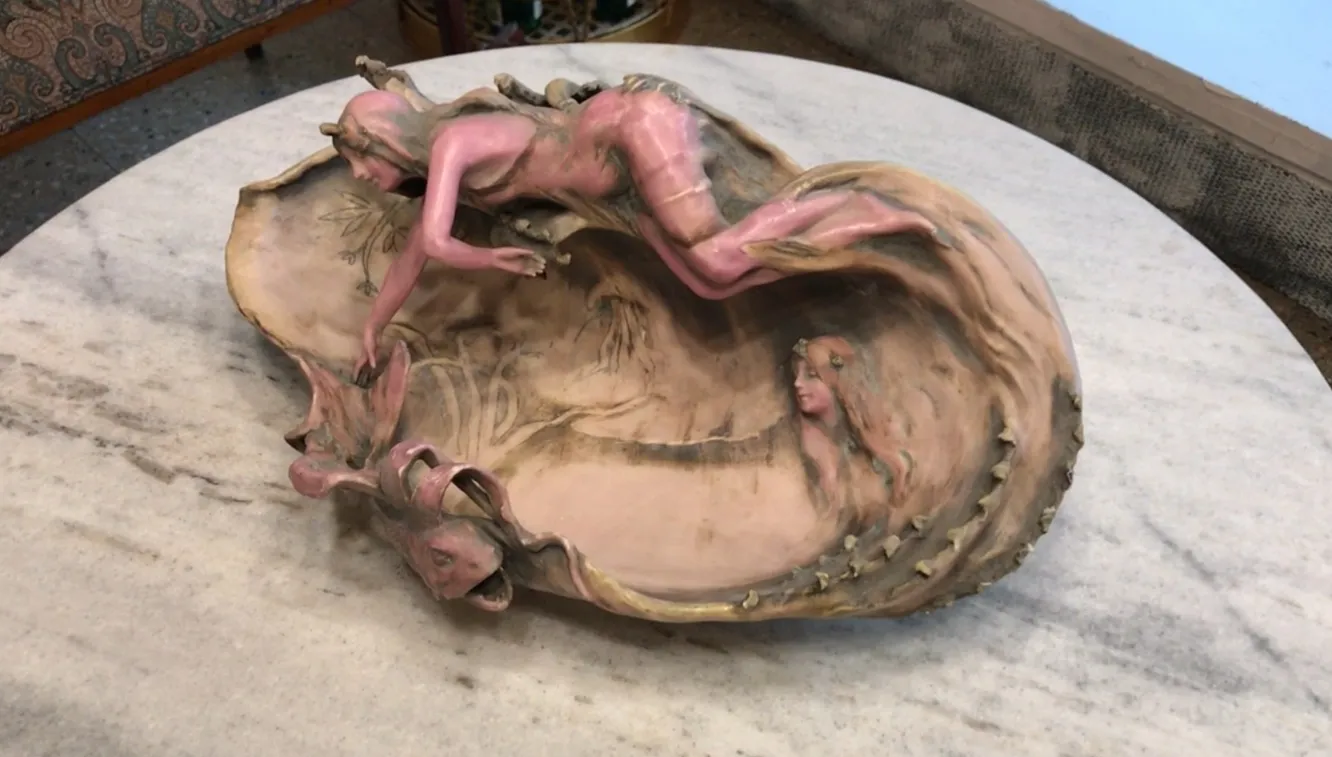 Porcelana antiga com figuras decorativas em tons de rosa e bege