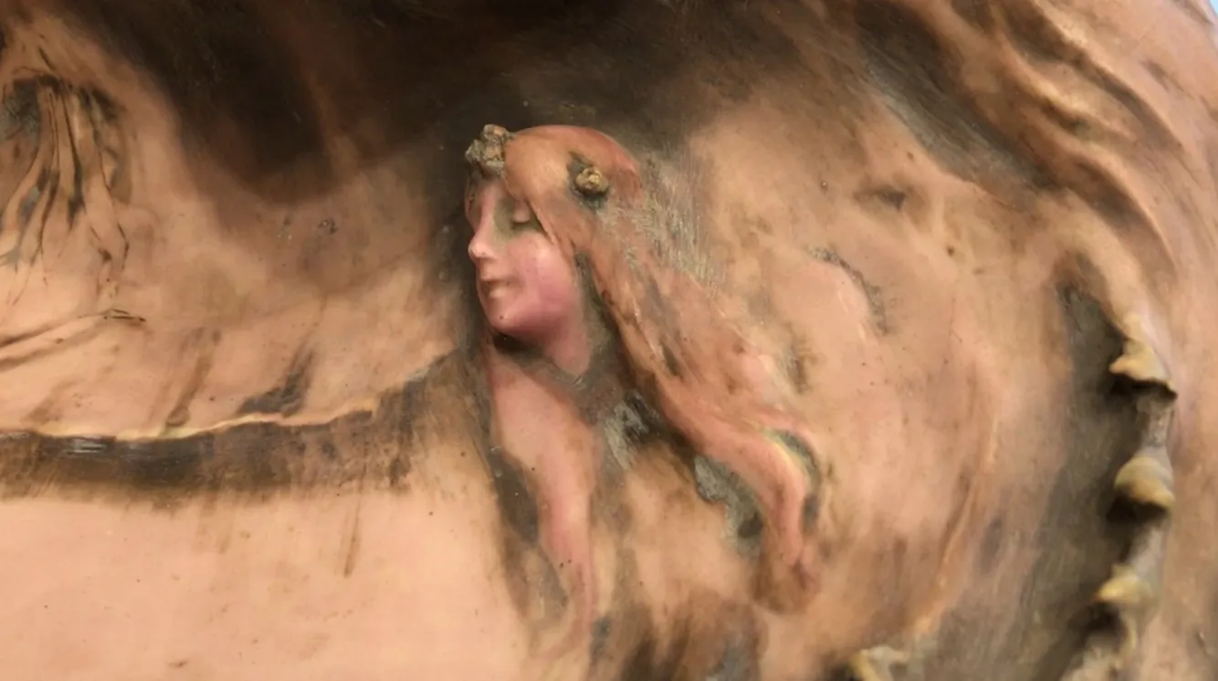 détail d'une figure ancienne en porcelaine avec de longs cheveux et une fleur