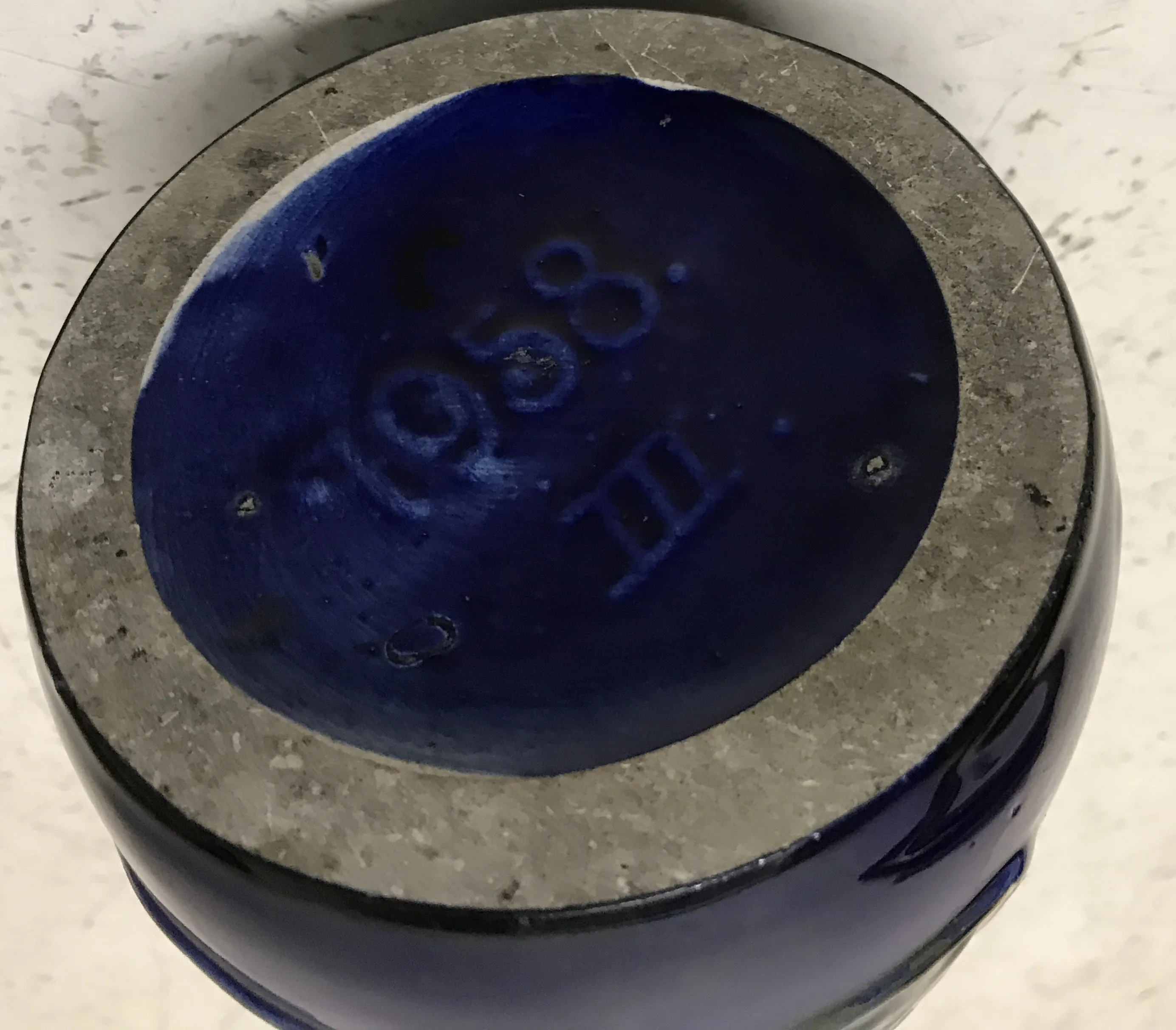 Antique ceramic piece with decorative blue base visible
