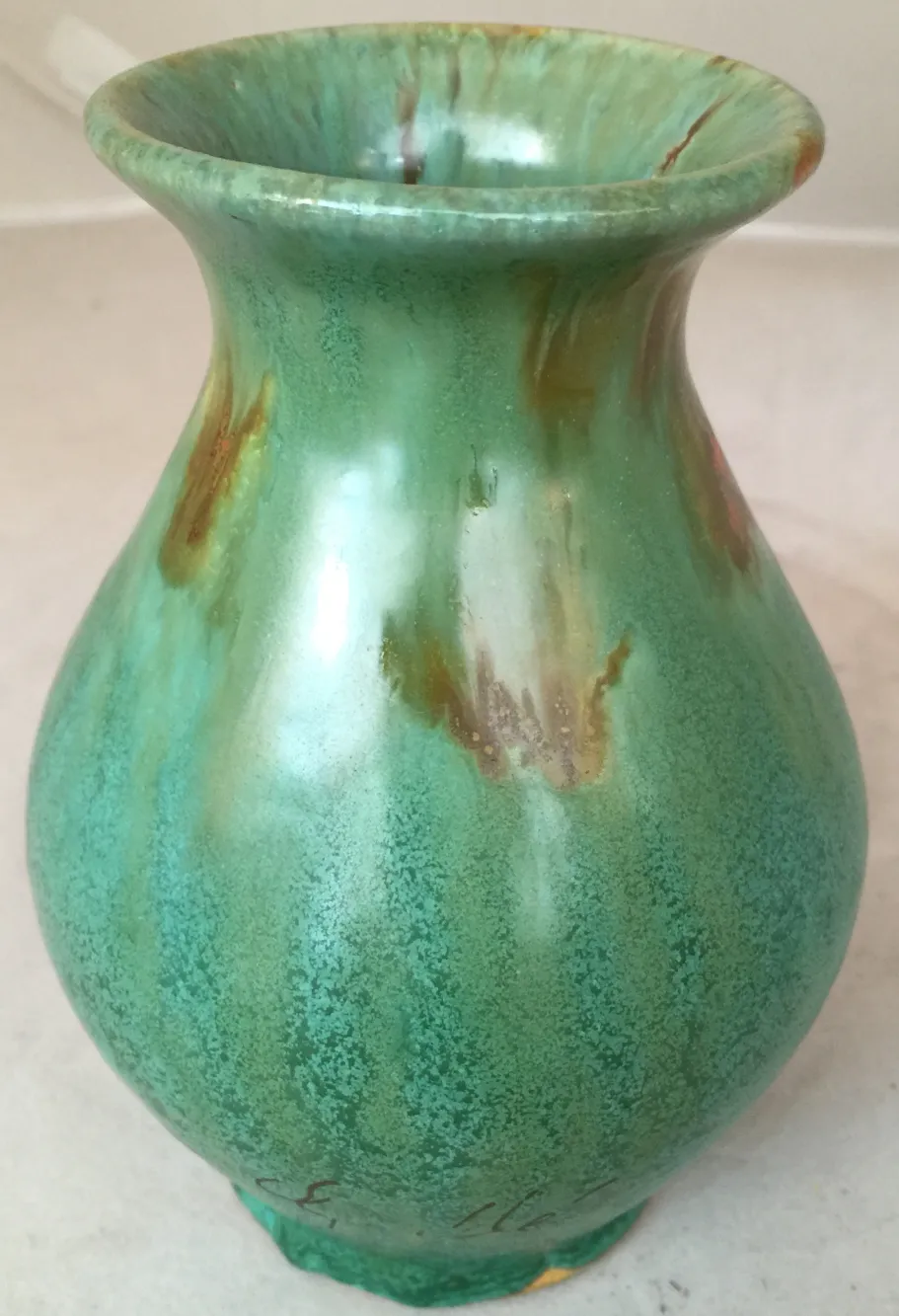 Vaso antico in ceramica con tonalità verdi e arancioni e dettagli decorativi unici