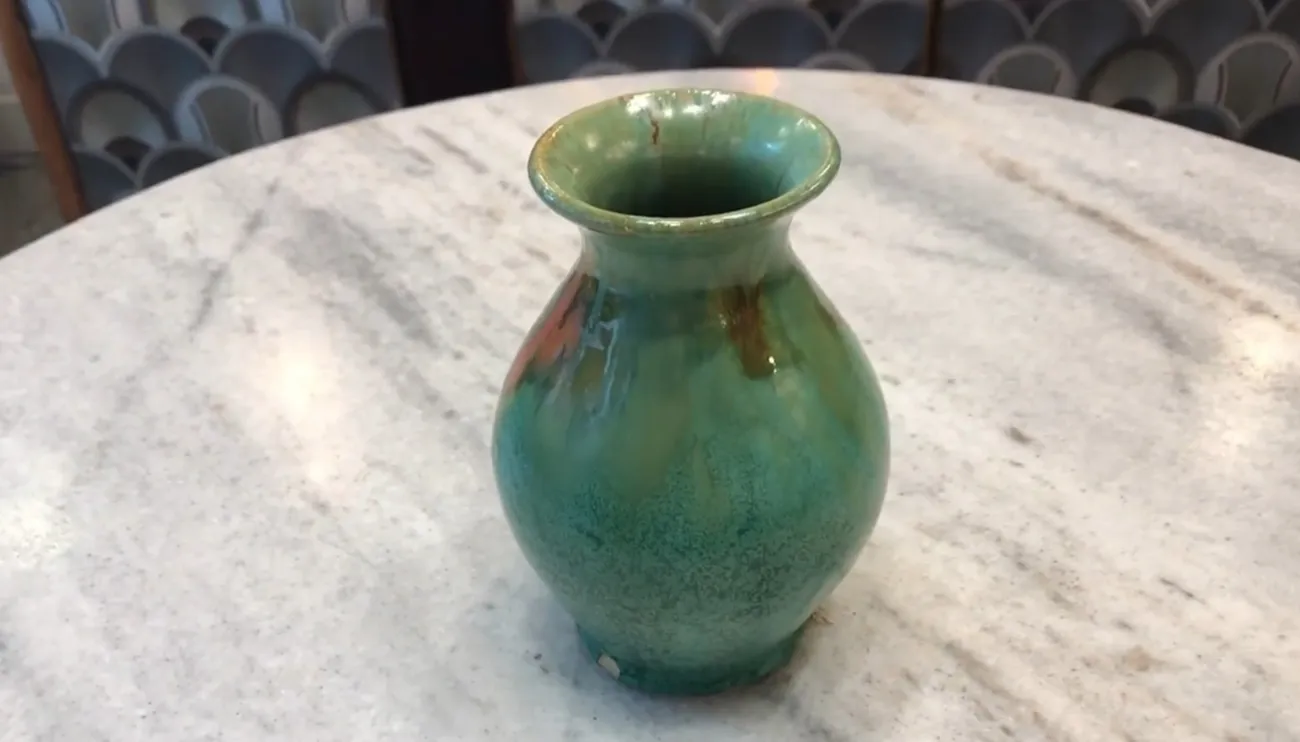 Vaso antico in ceramica con tonalità verdi e arancioni e dettagli decorativi unici