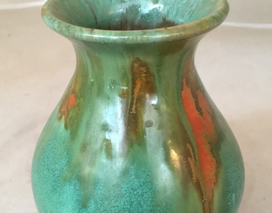 Antique ceramic vase in green and orange tones with unique decorative details