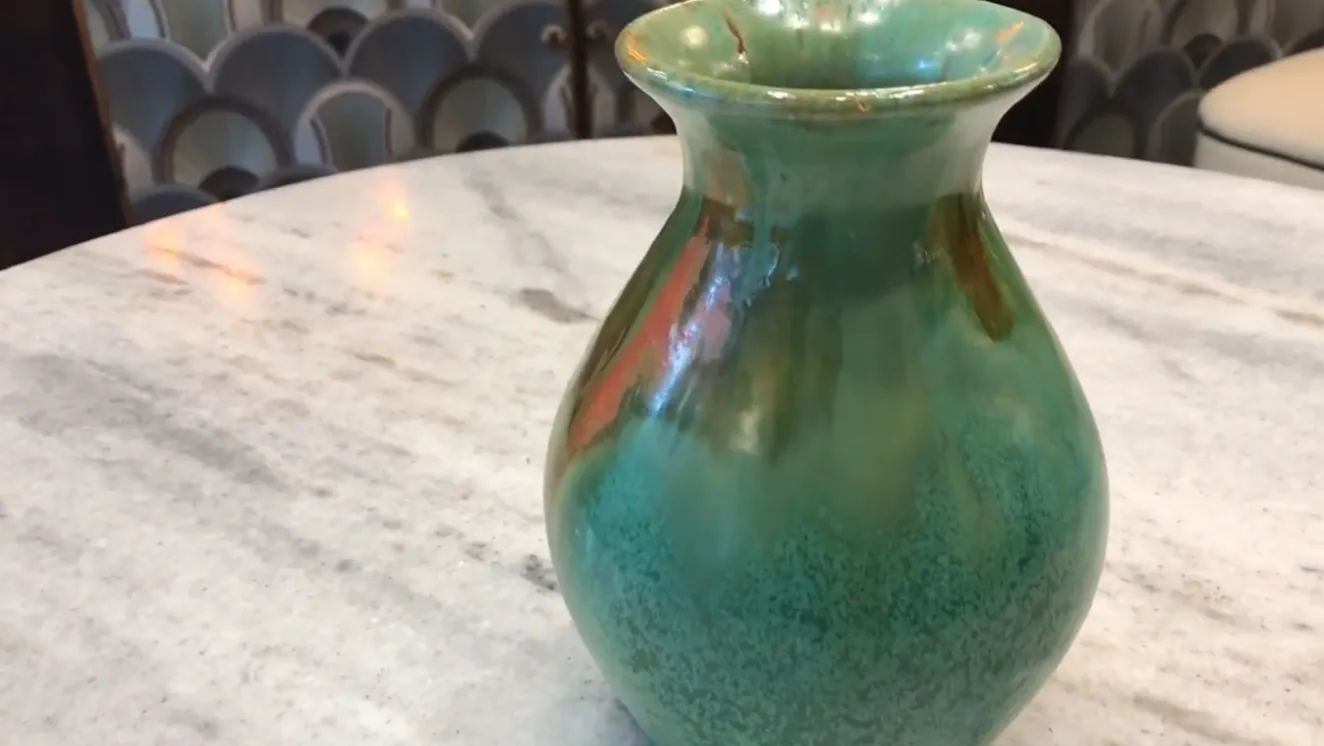 Vaso antico in ceramica con tonalità verdi e arancioni e dettagli decorativi unici