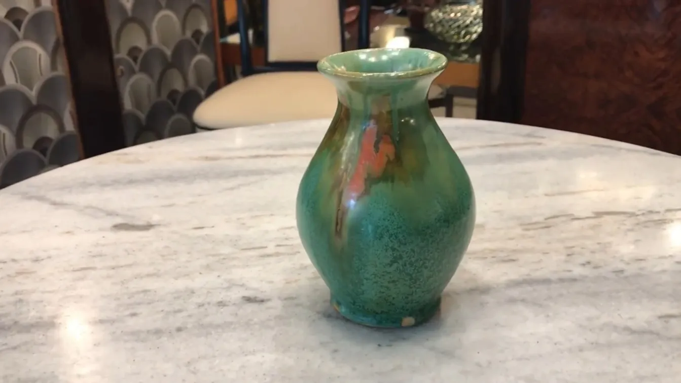 Vaso antico in ceramica con tonalità verdi e arancioni e dettagli decorativi unici