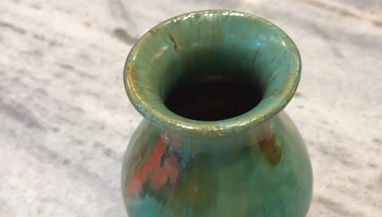 Vaso antico in ceramica con tonalità verdi e arancioni e dettagli decorativi unici