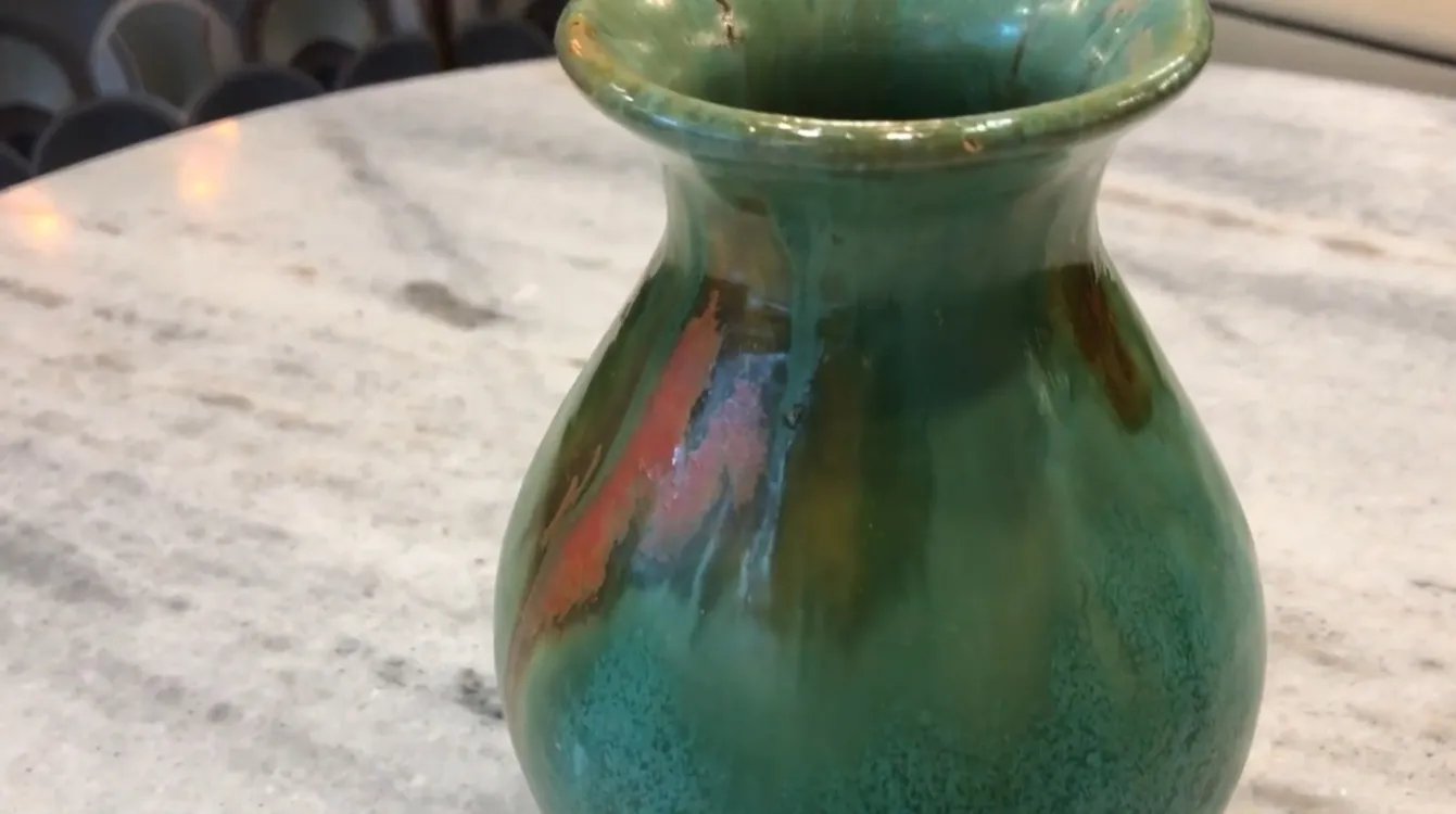 Vaso antigo de cerâmica em tons de verde e laranja com detalhes decorativos únicos