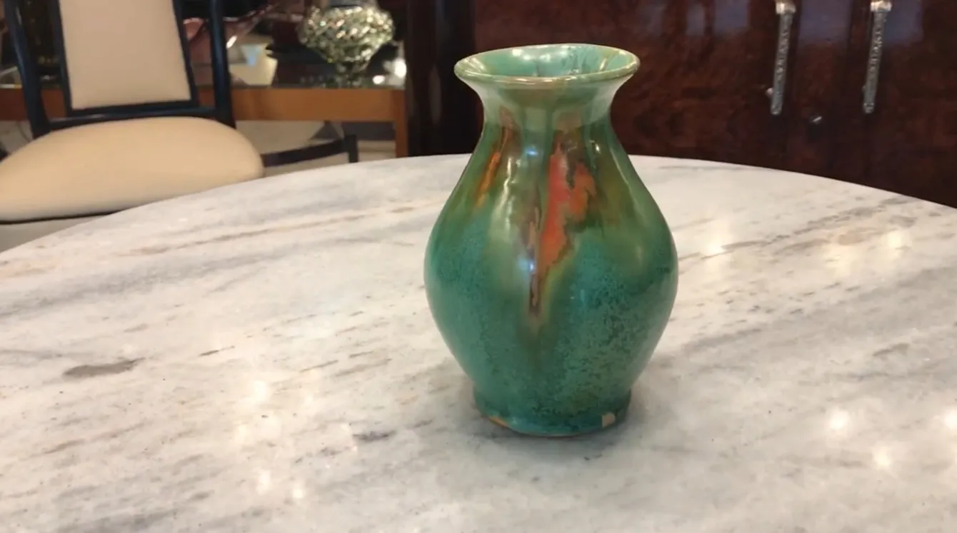 Vaso antico in ceramica con tonalità verdi e arancioni e dettagli decorativi unici