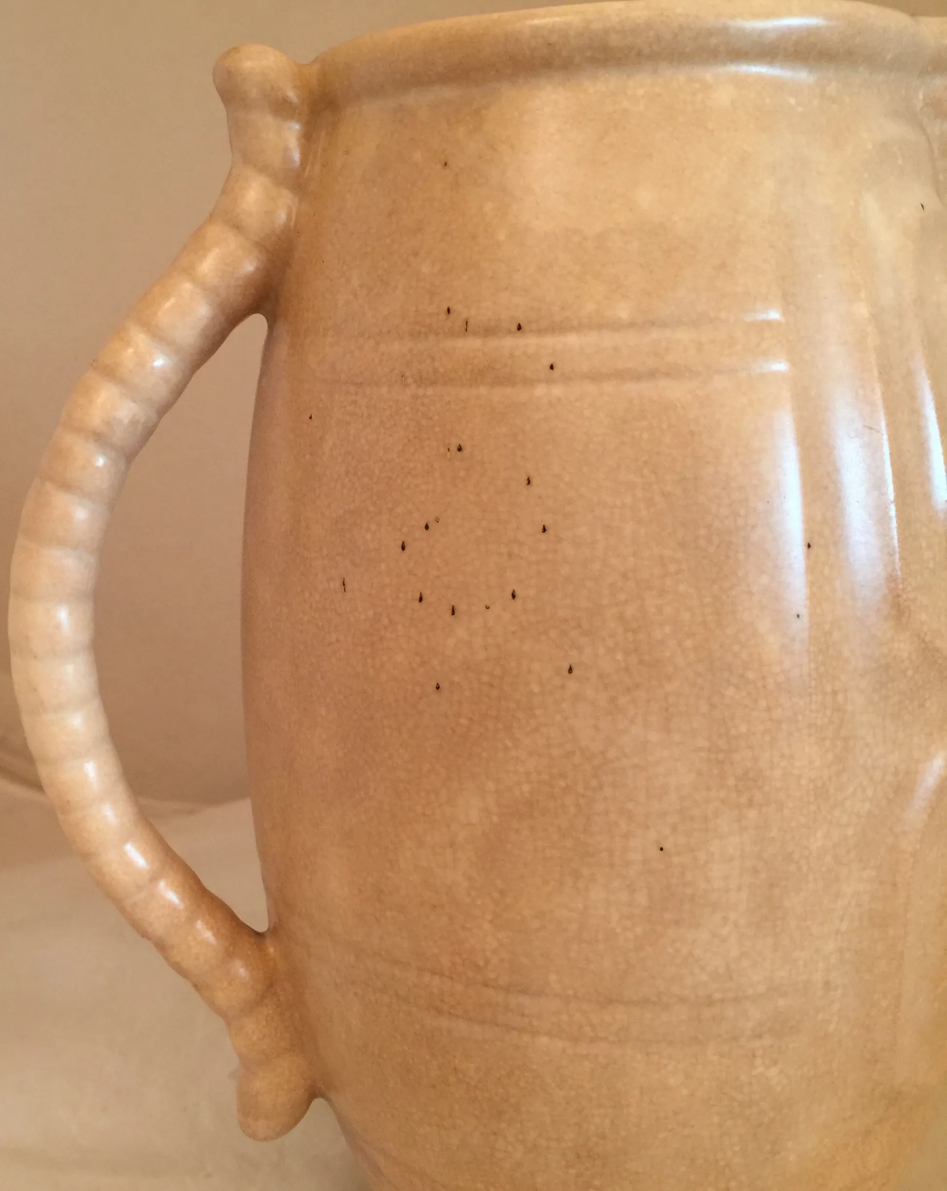 Antique ceramic jug featuring a dog handle and textured surface