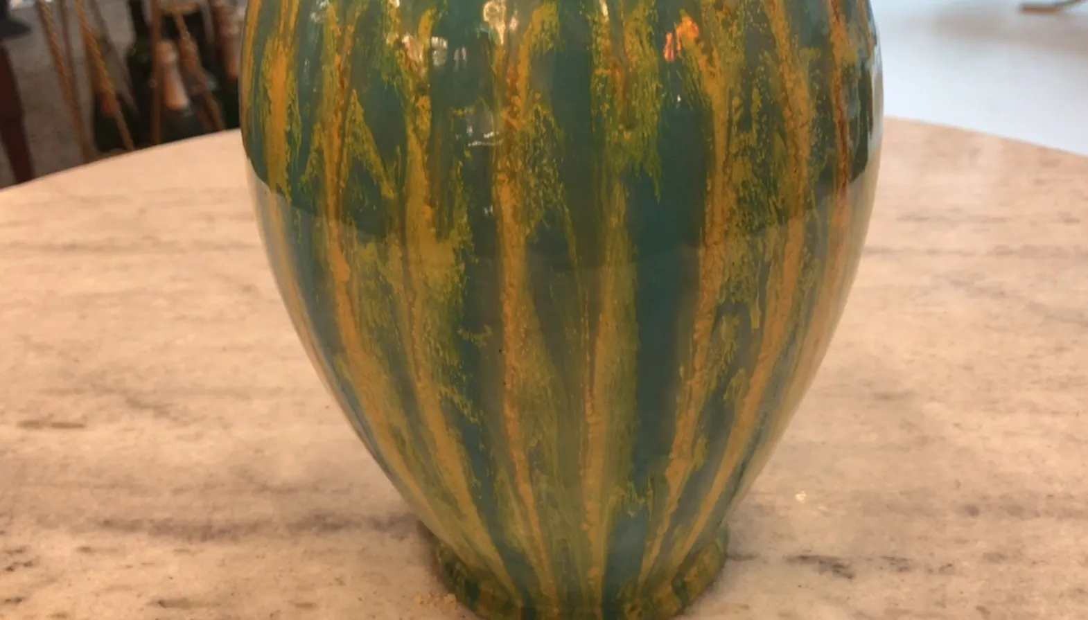 Taza de cerámica antigua con diseño colorido y línea decorativa.