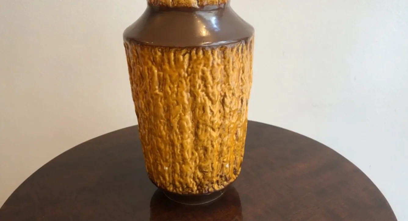 पुराना मिट्टी का पात्र, रंग एम्बर, खुरदुरी बनावट के साथ।