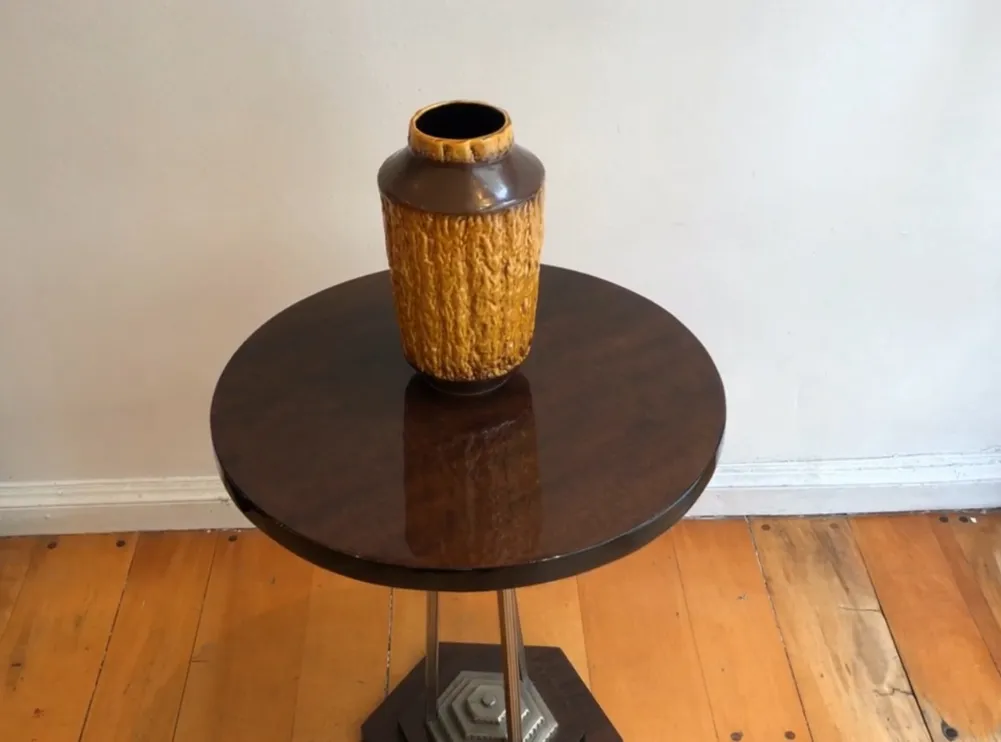 Antique ceramic vase with textured surface and warm colors on a table