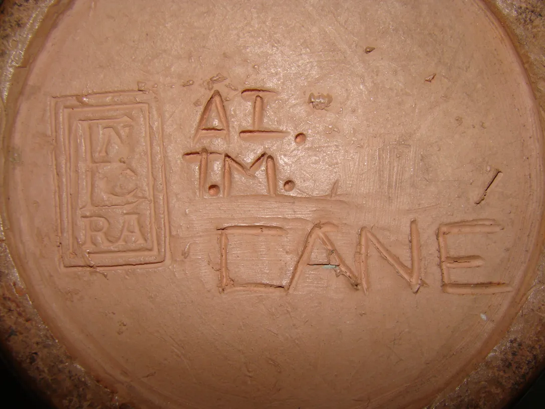 Antigua cerámica con sello grabado y textura suave.