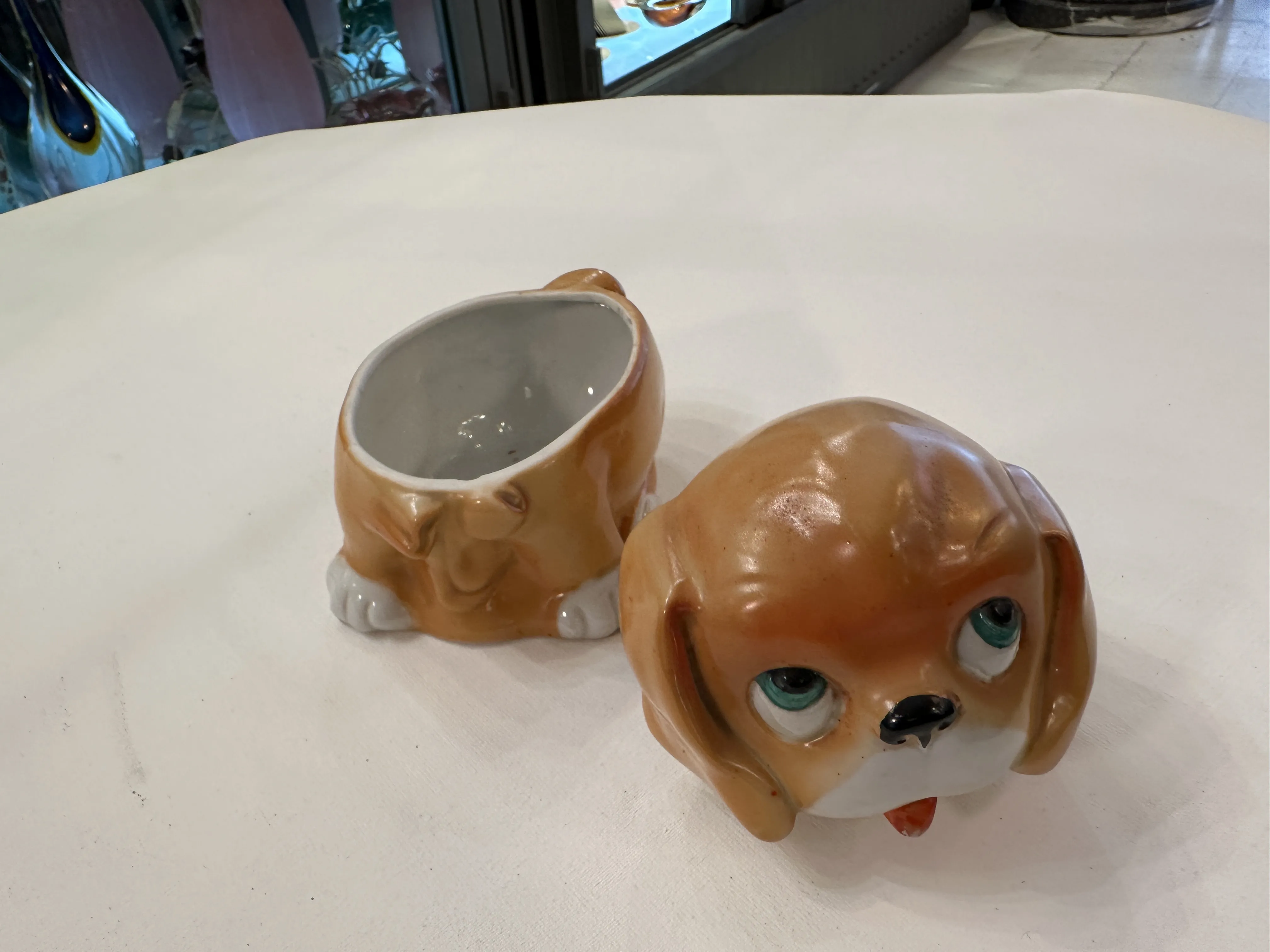 Cerâmica antiga decorativa em forma de cachorro, cor marrom claro, olhos azuis e língua vermelha