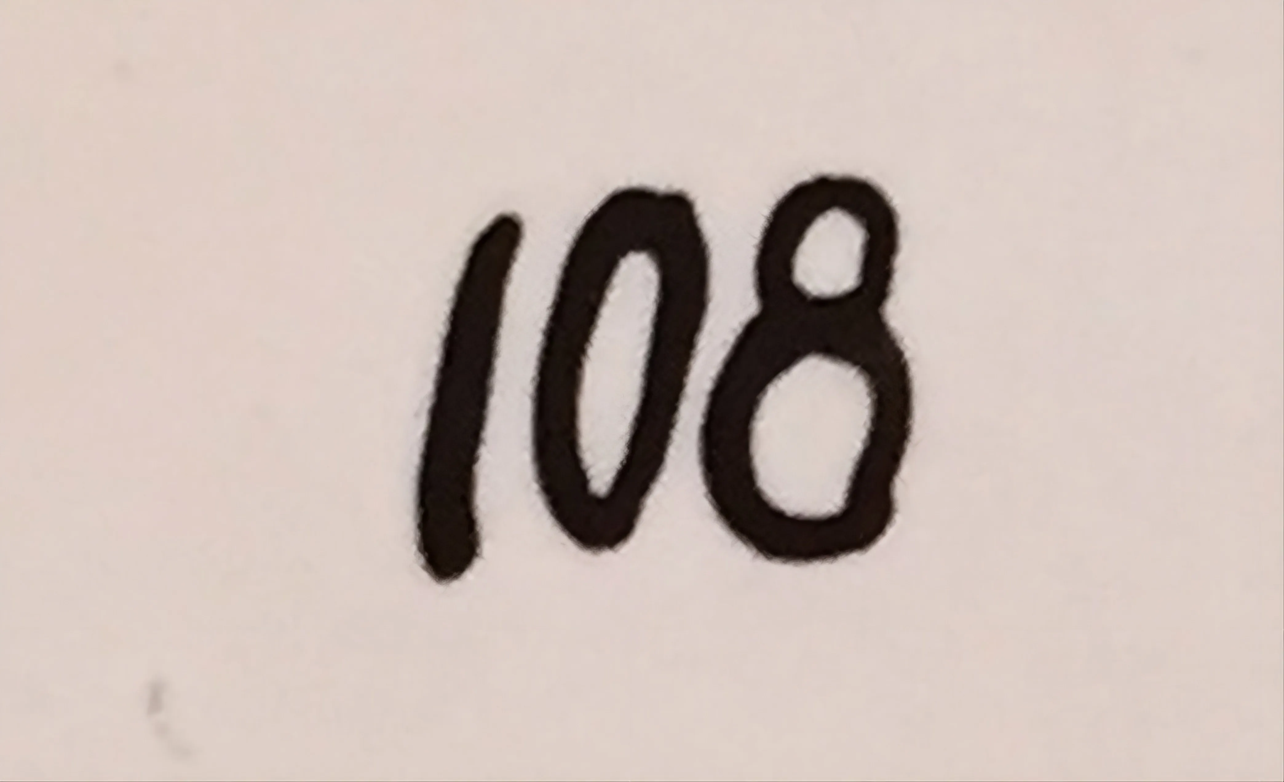 Número escrito en tinta negra sobre fondo claro, detalle de antigüedad cerámica.