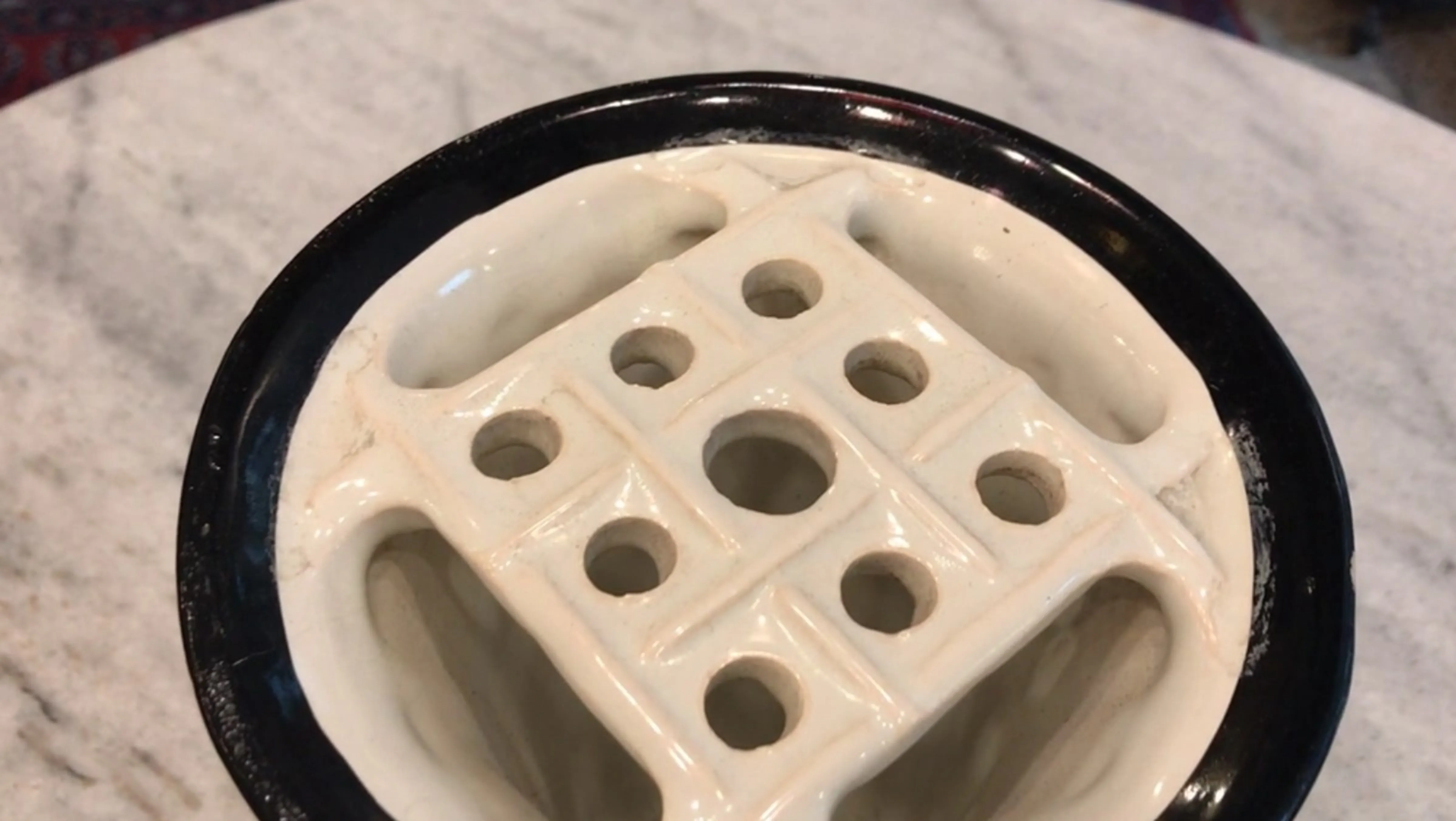 Antike Keramik von Rua Chile mit dekorativen Löchern und schwarzem Boden.