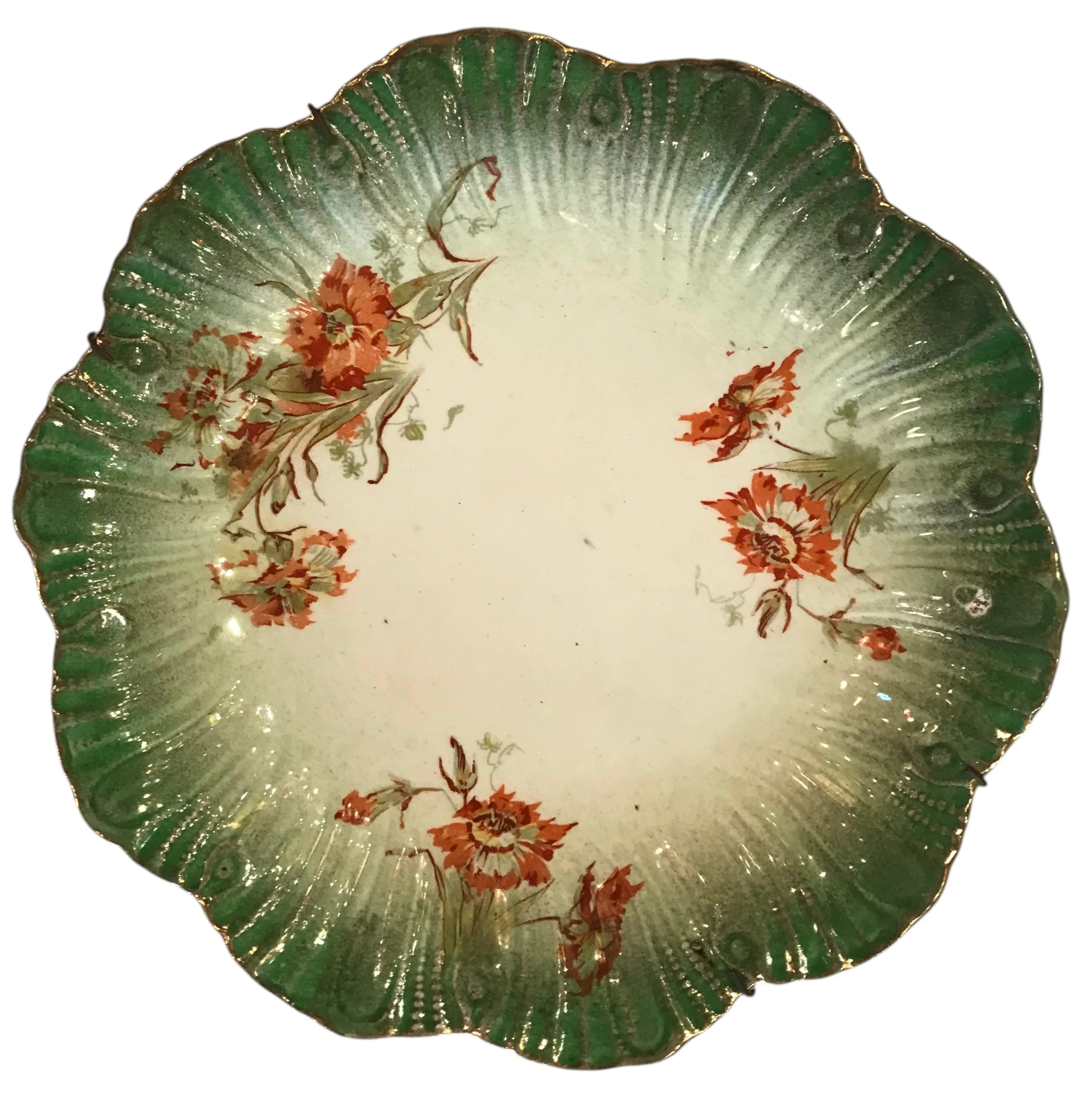 Plato antiguo de cerámica decorado con flores naranjas y verdes.