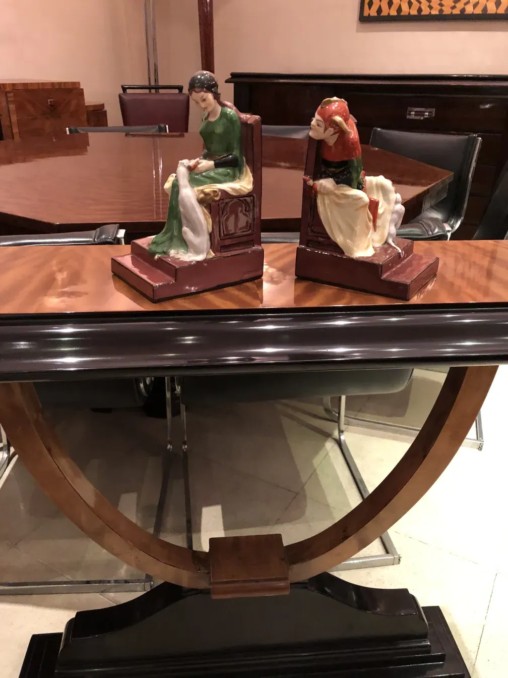 zwei antike buchstützen mit dekorativen figuren auf einem stilvollen tisch