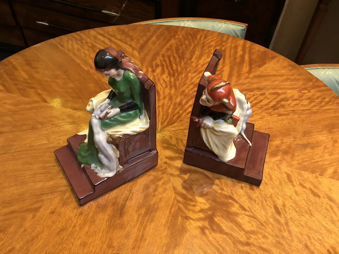 antique bookends featuring a female figure in green and a male figure