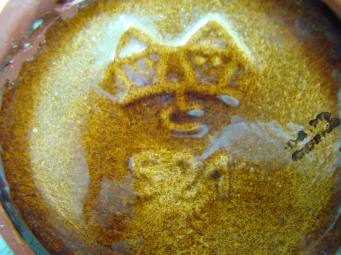 Antigua cerámica con un fondo marrón brillante y un diseño único de Carstens Tönnieshof.