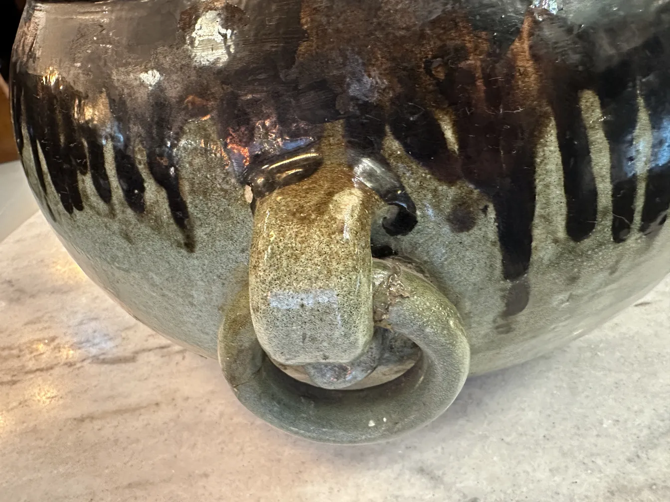 Antigua cerámica dorada con tiradores y detalles oscuros