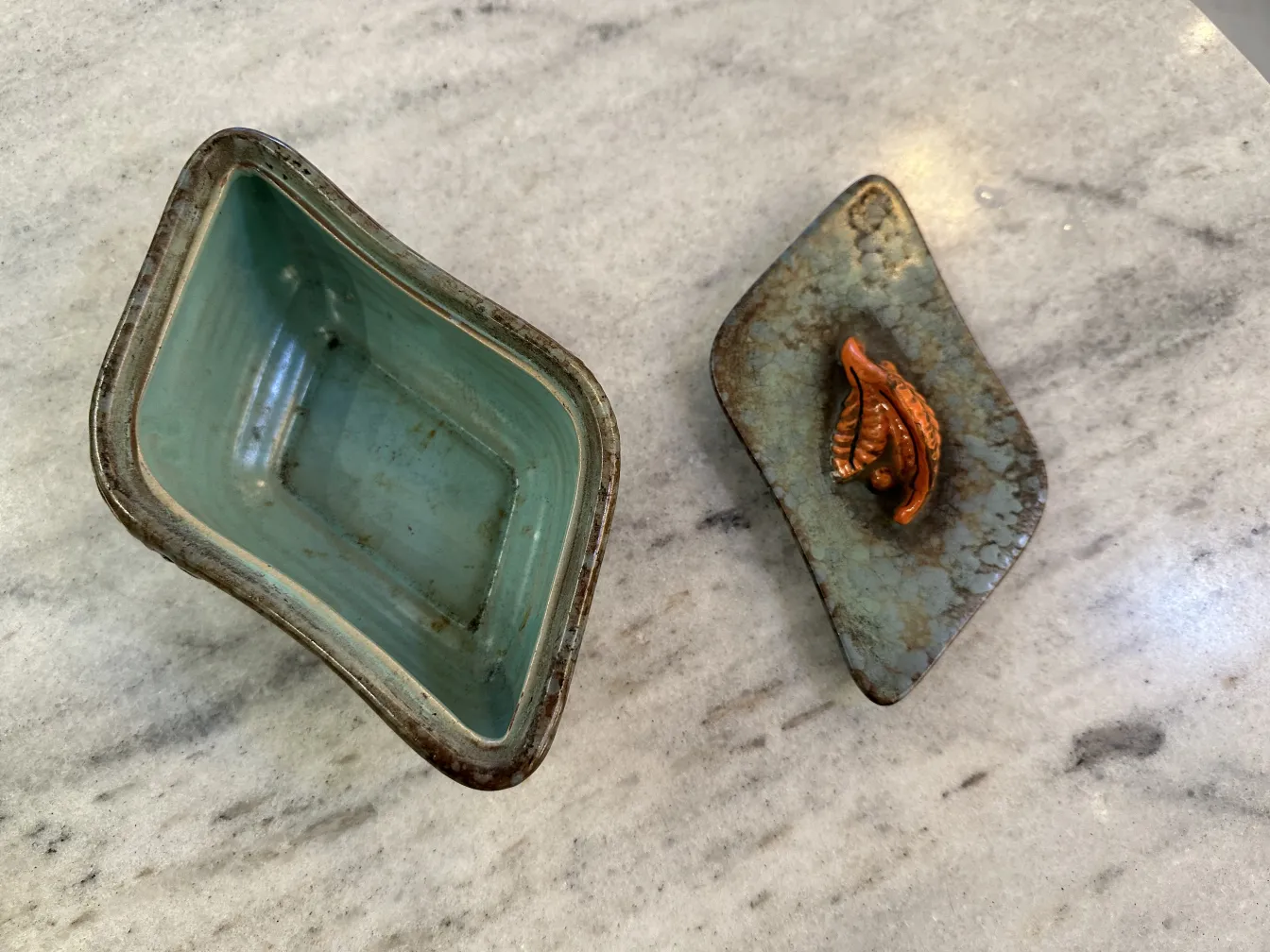 Ceramica antigua decorada con hojas en tonos naranja y marrón